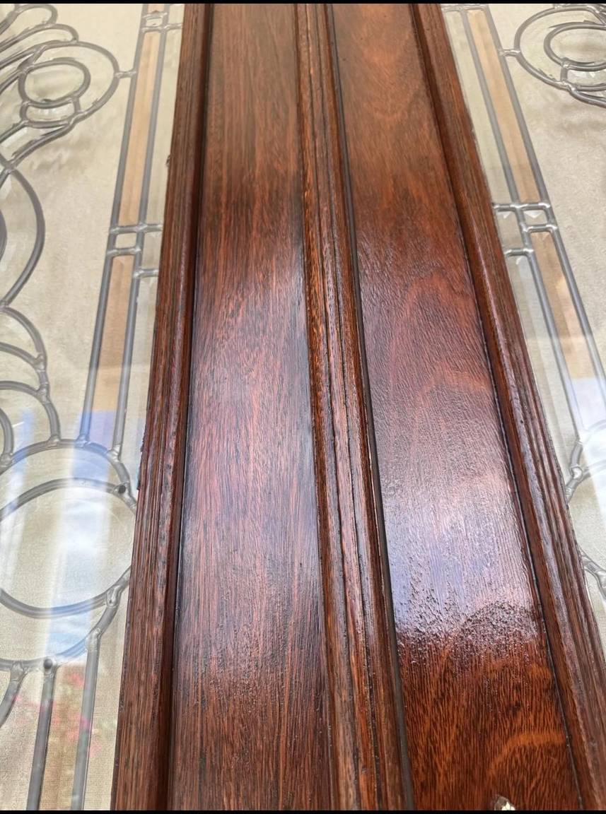 Close-up of the restored door showing rich dark wood grain after refinishing
