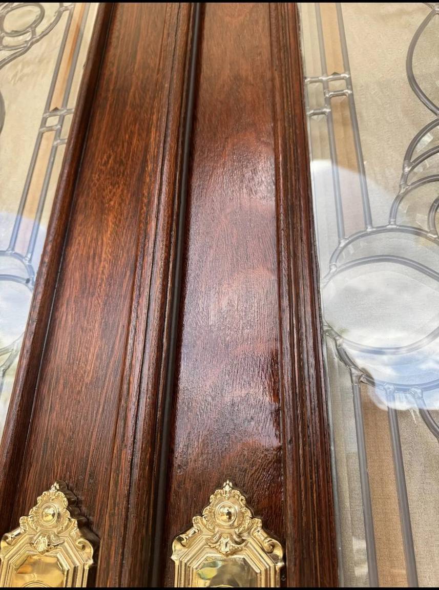Close-up of restored dark wood finish and ornate brass door handles